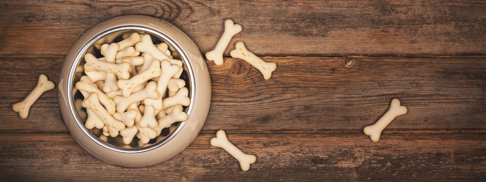 A bowl of dog biscuits on a wood floor